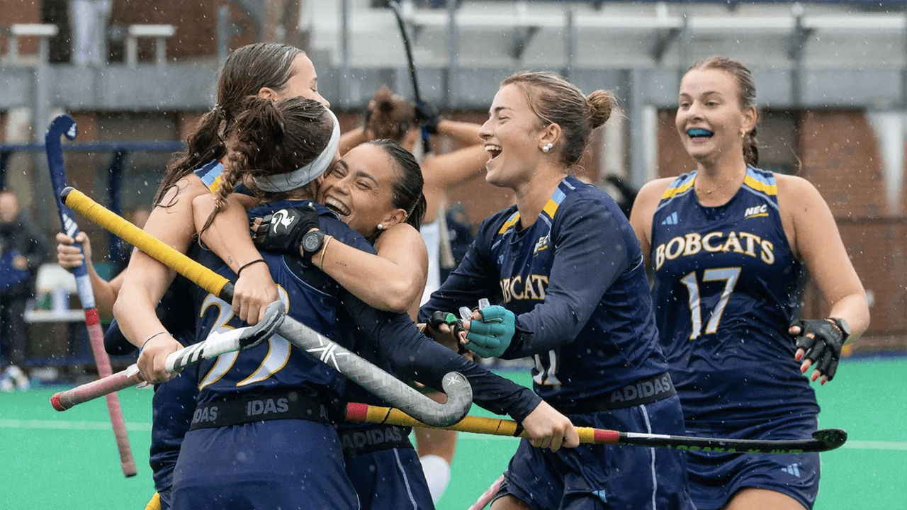 Field hockey players celebrating.