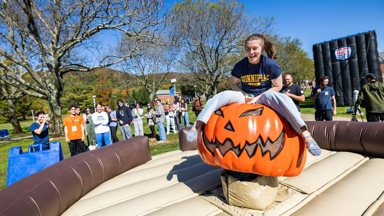 A person sits on a mechanical pumpkin