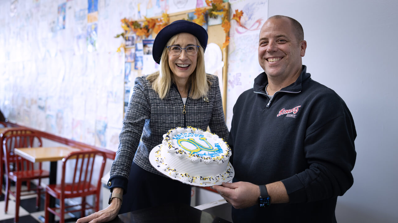 Brian Anderson and Marie Hardin pose with a custom Quinnipiac ice cream cake