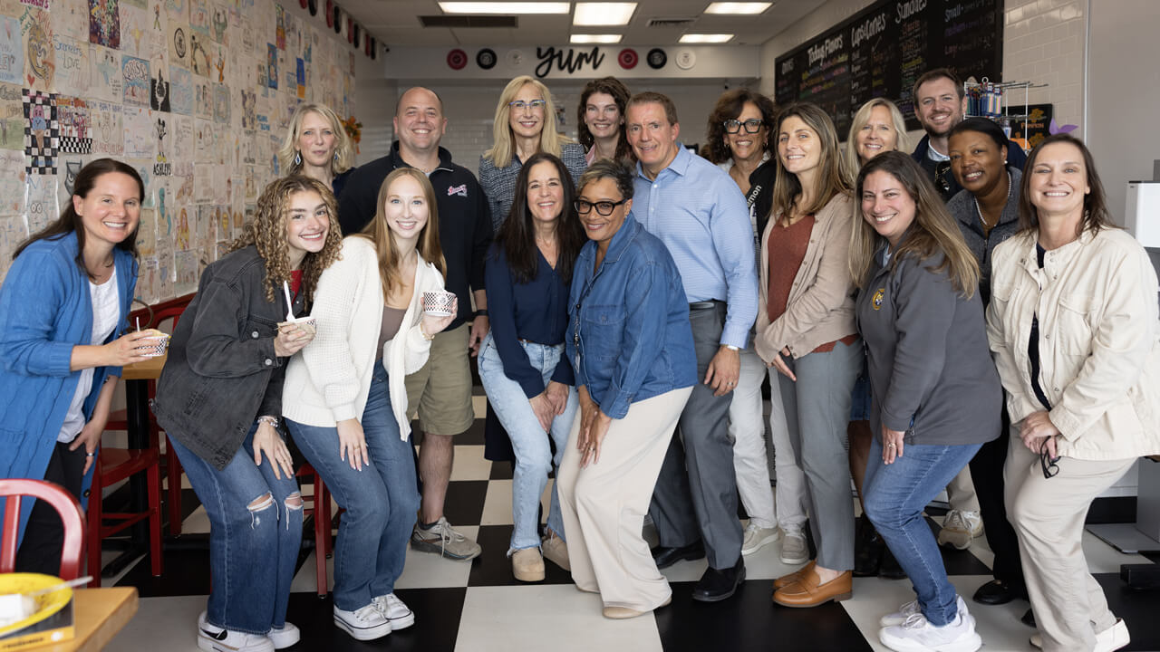 A dozen Quinnipiac community members pose for a photo in Ashley's Ice Cream shop