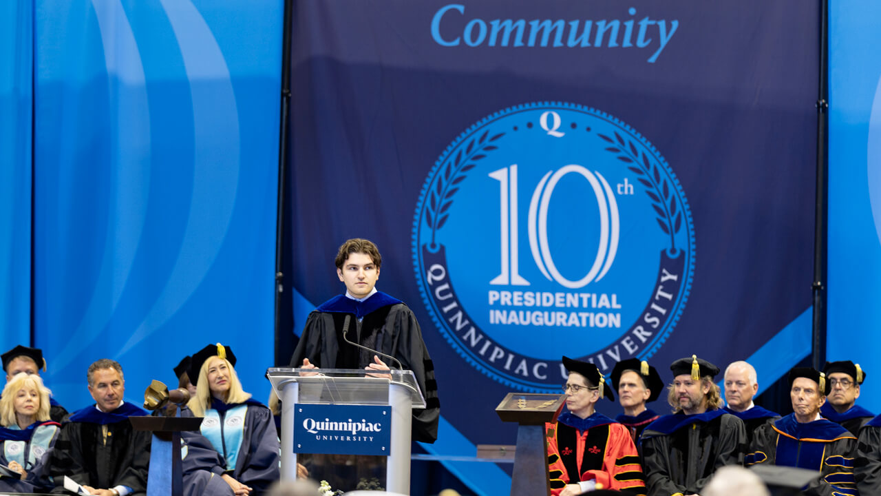 Zachary O’Connell speaks at the podium while the platform party looks on