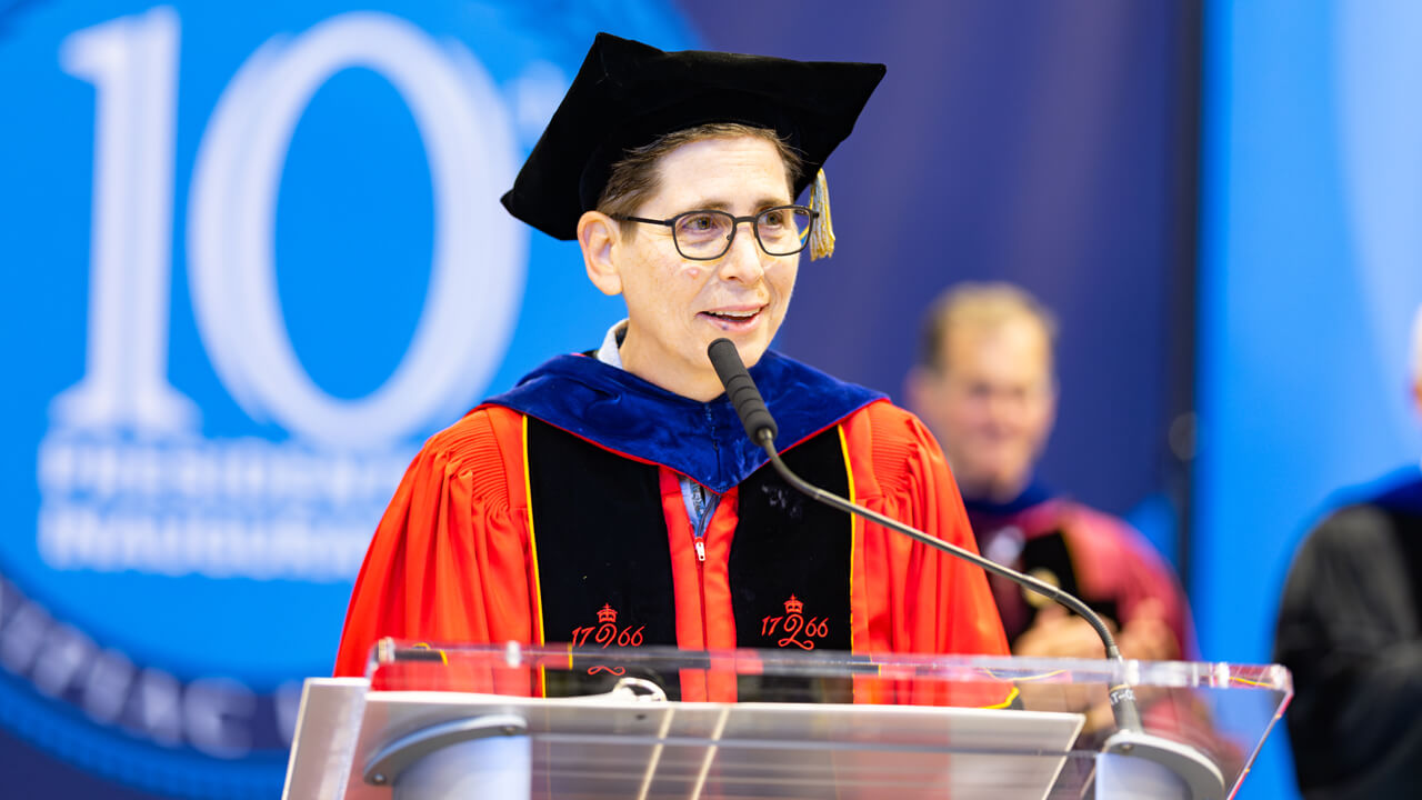 Deb Liebowitz speaks at the podium on stage
