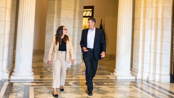 2 professionals walking down a hallway