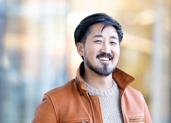 Jason Koo smiling in an orange jacket