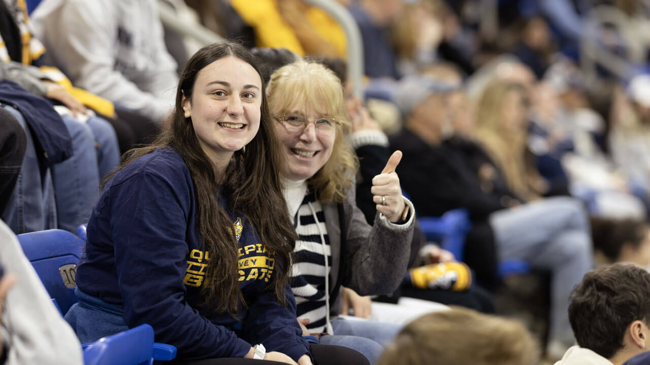 Mom and daughter smile at Quinnipiac mens ice hockey game