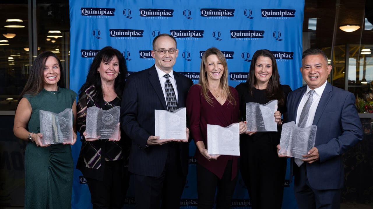 Six Center for Staff and Faculty Excellence Award recipients smile for a photos while holding their awards.