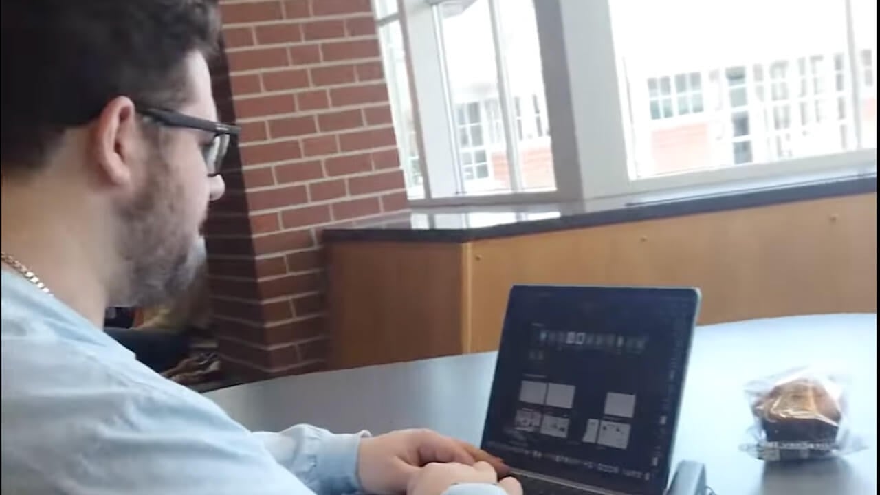 Paul Cappuzzo looking at his laptop, plays video