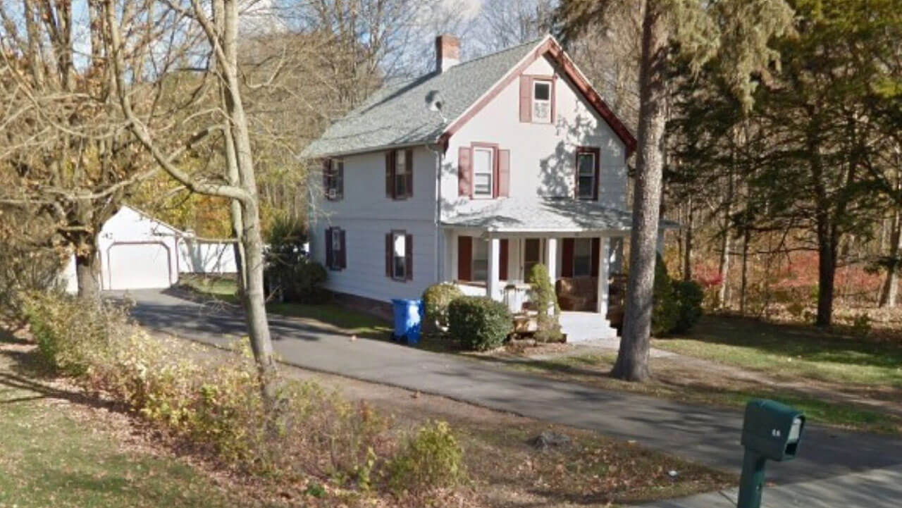 Neighboring trees around two story house and separate garage on 86 Ives Street