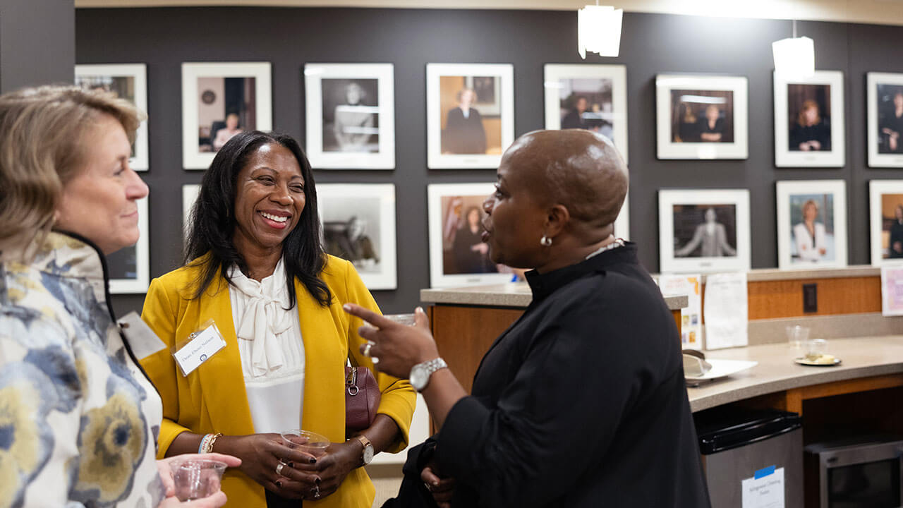 Three women converse during a School of Law event about female judges