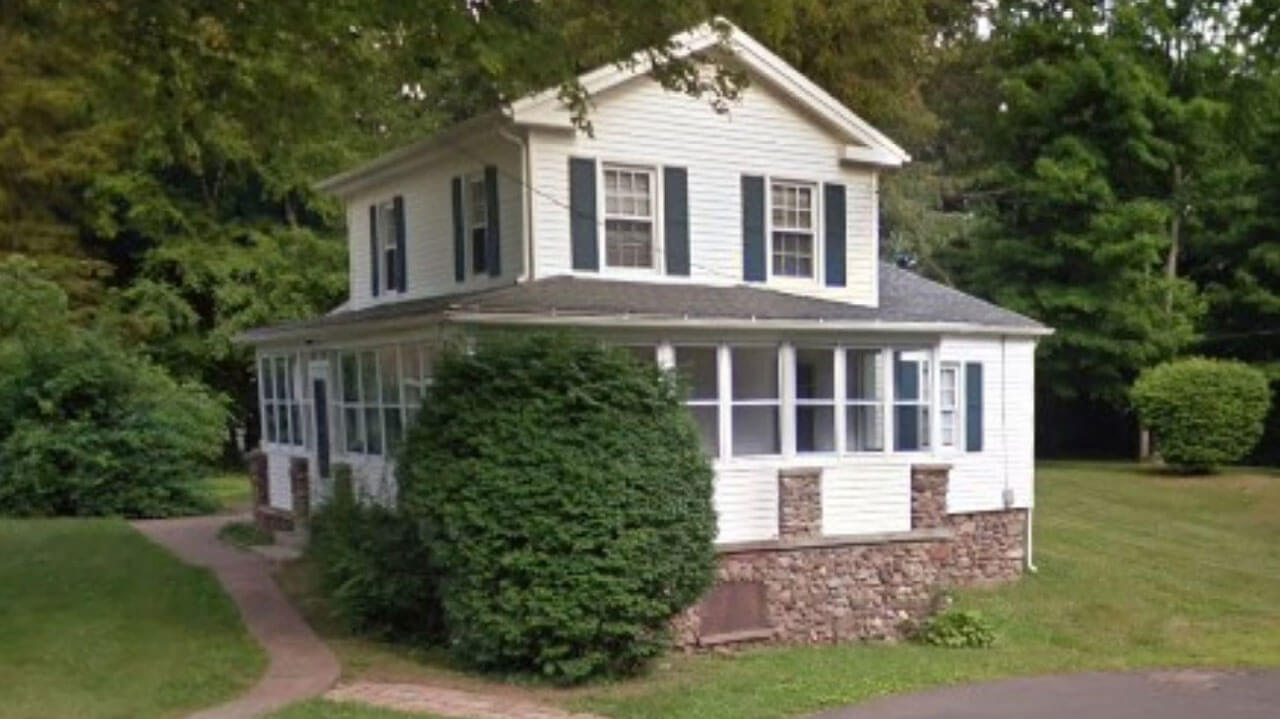 White two story house with greenery surrounding it on 132 New Road