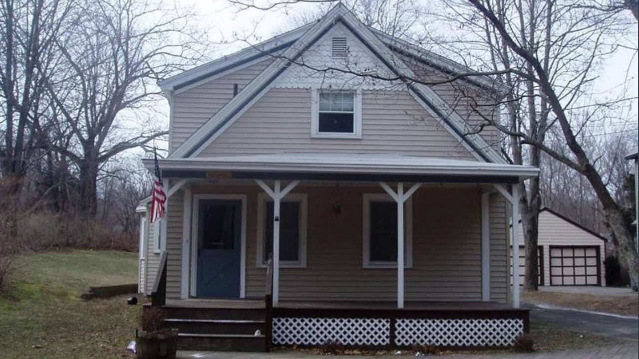 Tan house with a porch in front on 188 New Road