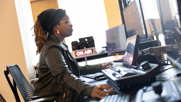 An international student operates equipment in a film studio