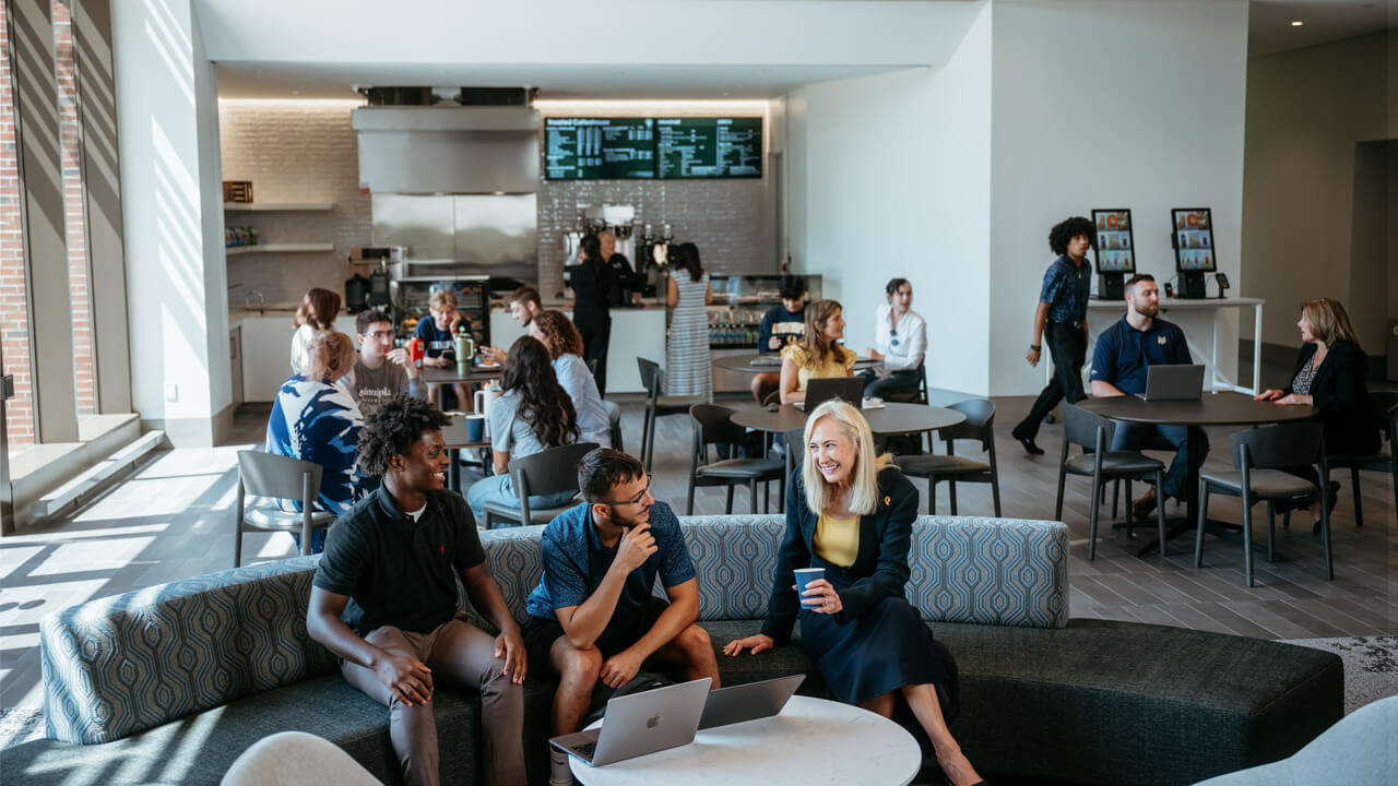 3 people sitting on a couch at the School of Business Cafe