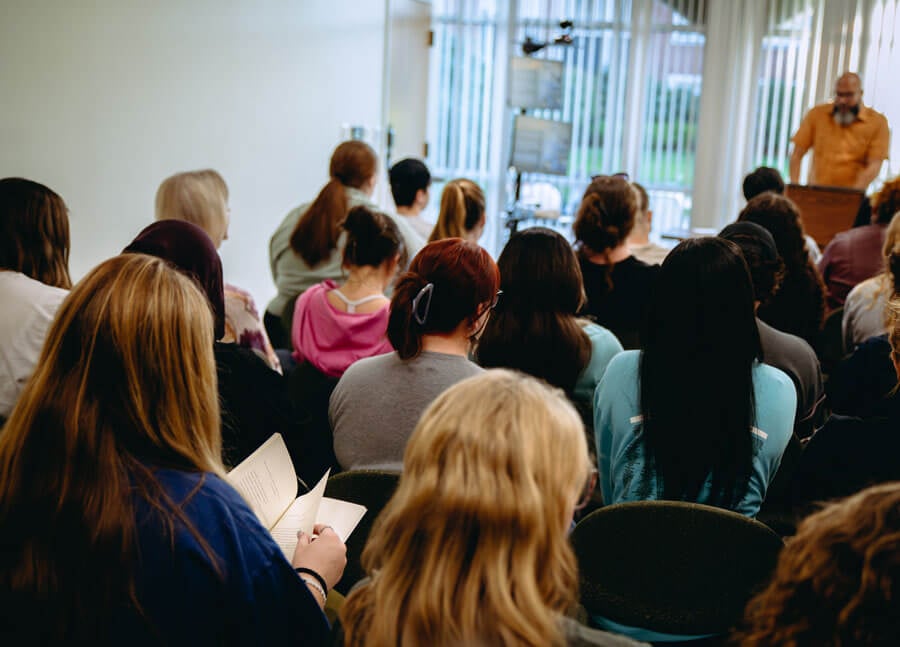 Students listen and read along with a visiting acclaimed poet.