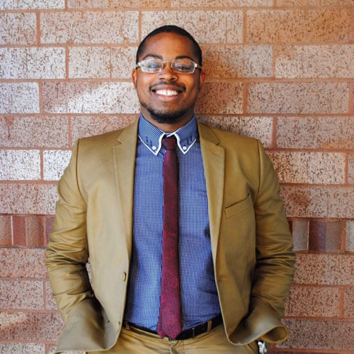 Jahmil Effend stands in front of a brick wall