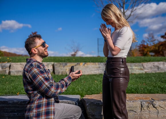 Two people getting engaged at surprise proposal