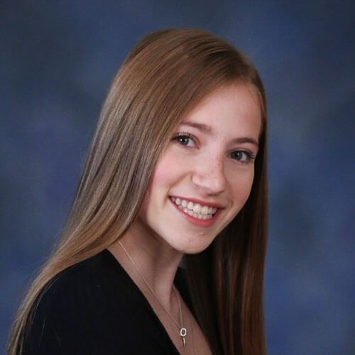 Photo of Justine Lewicki with a blue background.