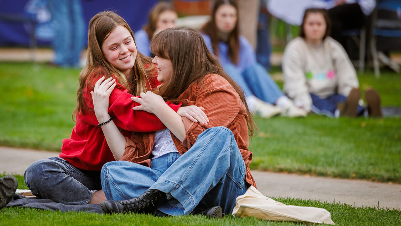 Concert goers hugging on a blanket on the quad