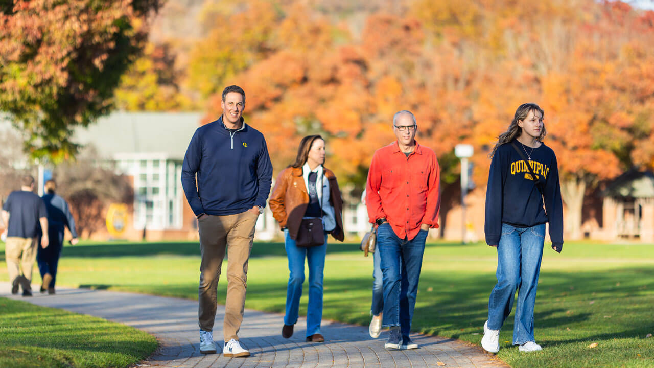 A family walks across the quad on the Mount Carmel Campus.