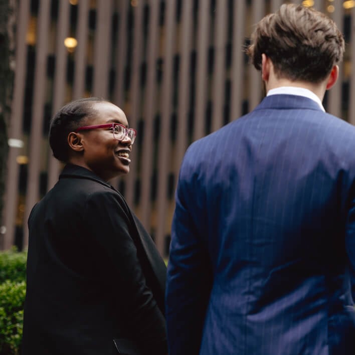 Two business students walking through the city in professional attire.