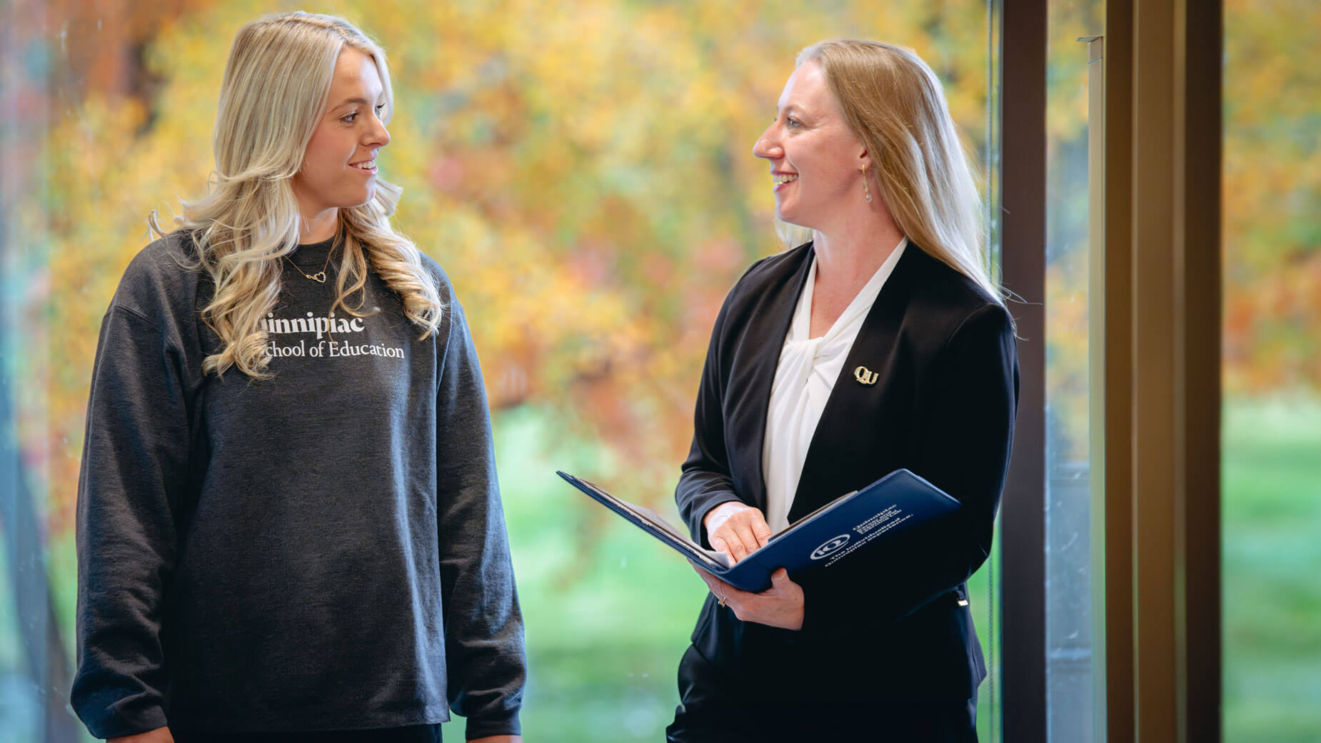 An education student walks with the Dean of Education, Anna Brady