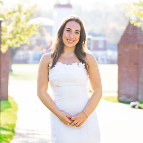 Photo of student, Madison Fahlborg, with the Arnold Bernhard Library in the background.