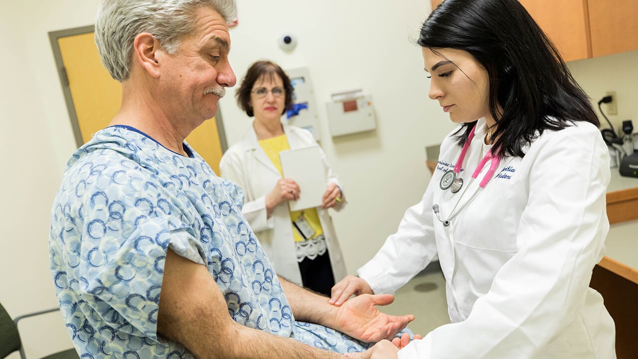 A doctor of nursing practice student performs an exam on an actor portraying a patient in the Standardized Patient Assessment Center on the North Haven Campus.