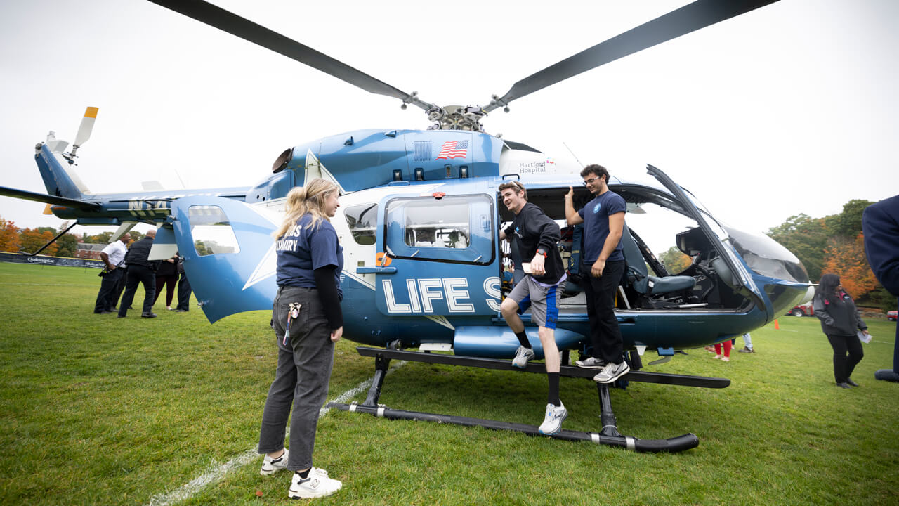 Three students looking at CT Life Star helicopter