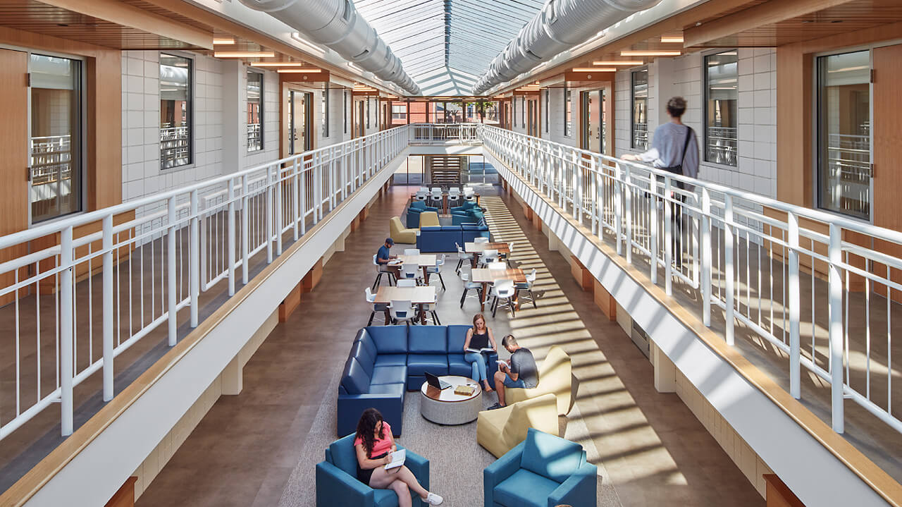 A two-story atrium under skylights in the Perlroth residence hall