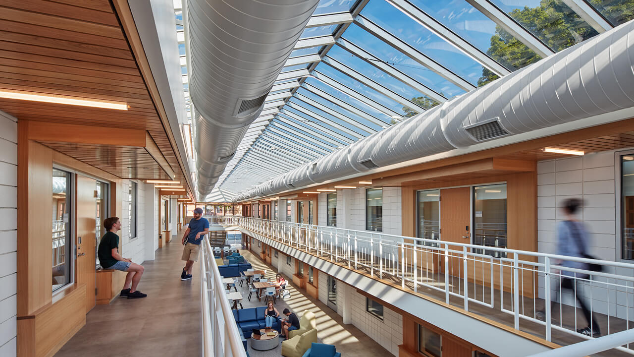 Students talk together on the first and second floor of the sunny atrium