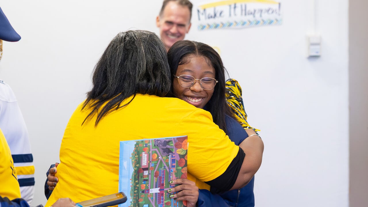 A newly admitted Quinnipiac student hugs her mom after receiving her acceptance