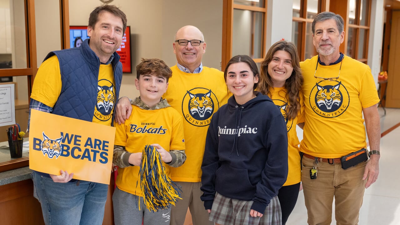 A newly admitted student and her family wear gold Bobcat shirts and pose for a photo together