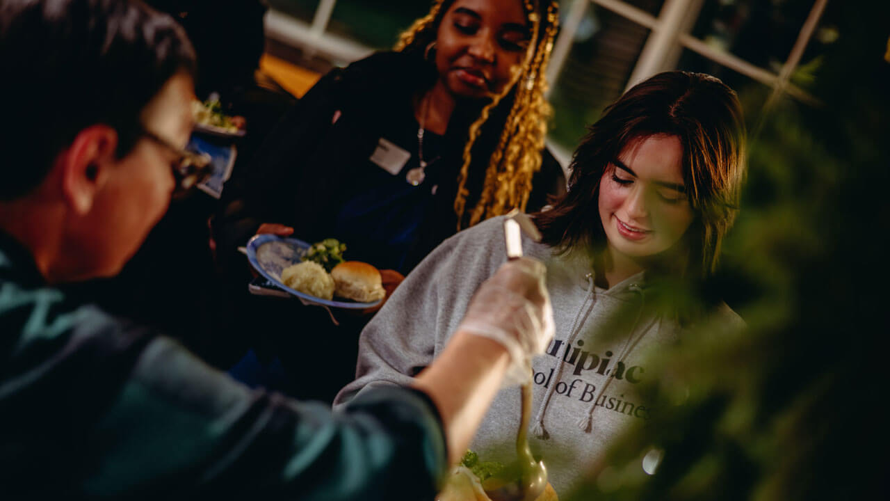 Professor serving student gravy in the Carl Hansen Student Center