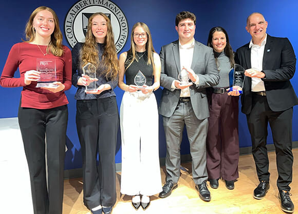 The Agency students and professors standing together with their awards