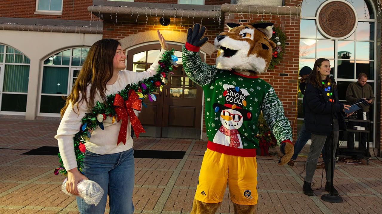 Boomer the Bobcat high fives student contest winner