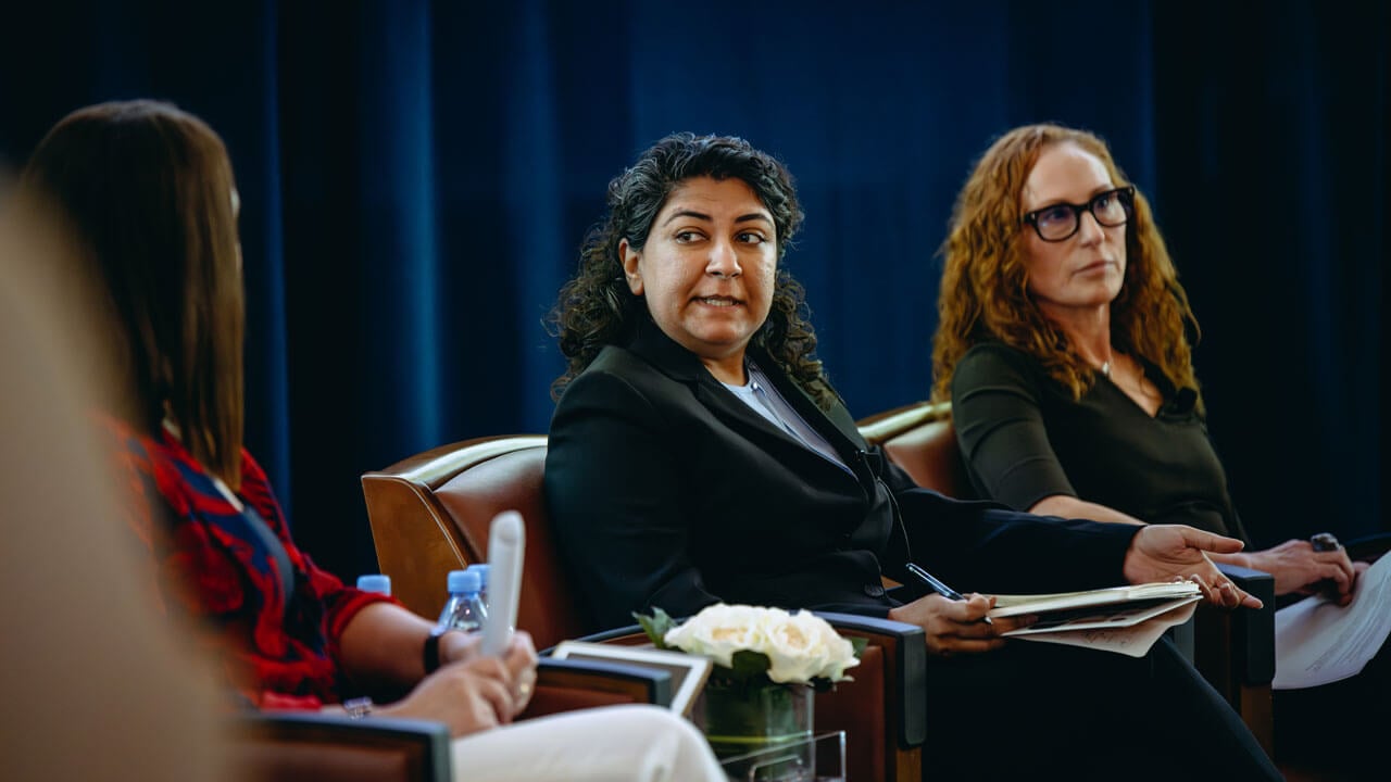 A panelist speaks to people next to them.