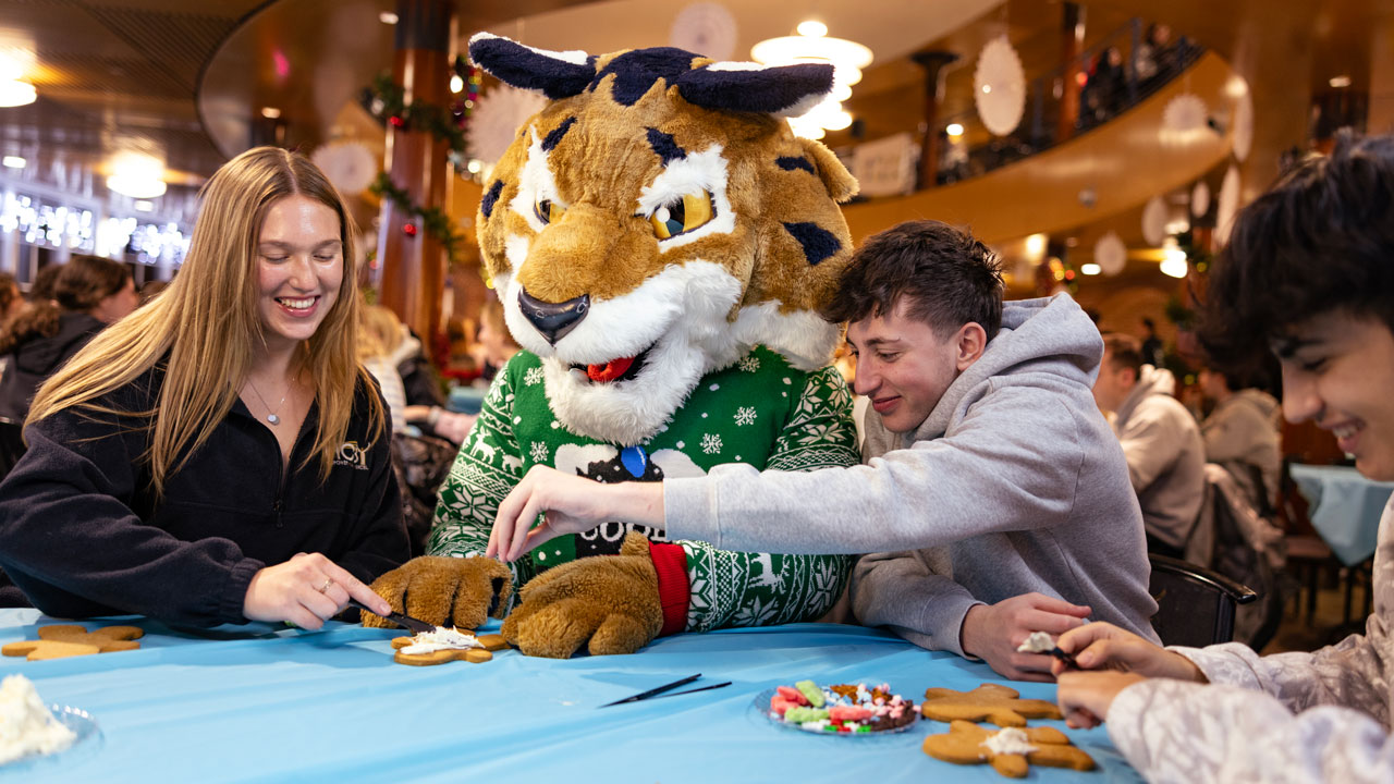 Students assist Boomer in decorating holiday cookies