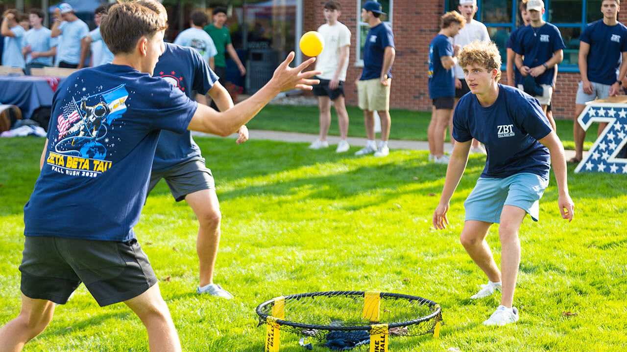 Fraternity members play outdoor activities together on the Quad