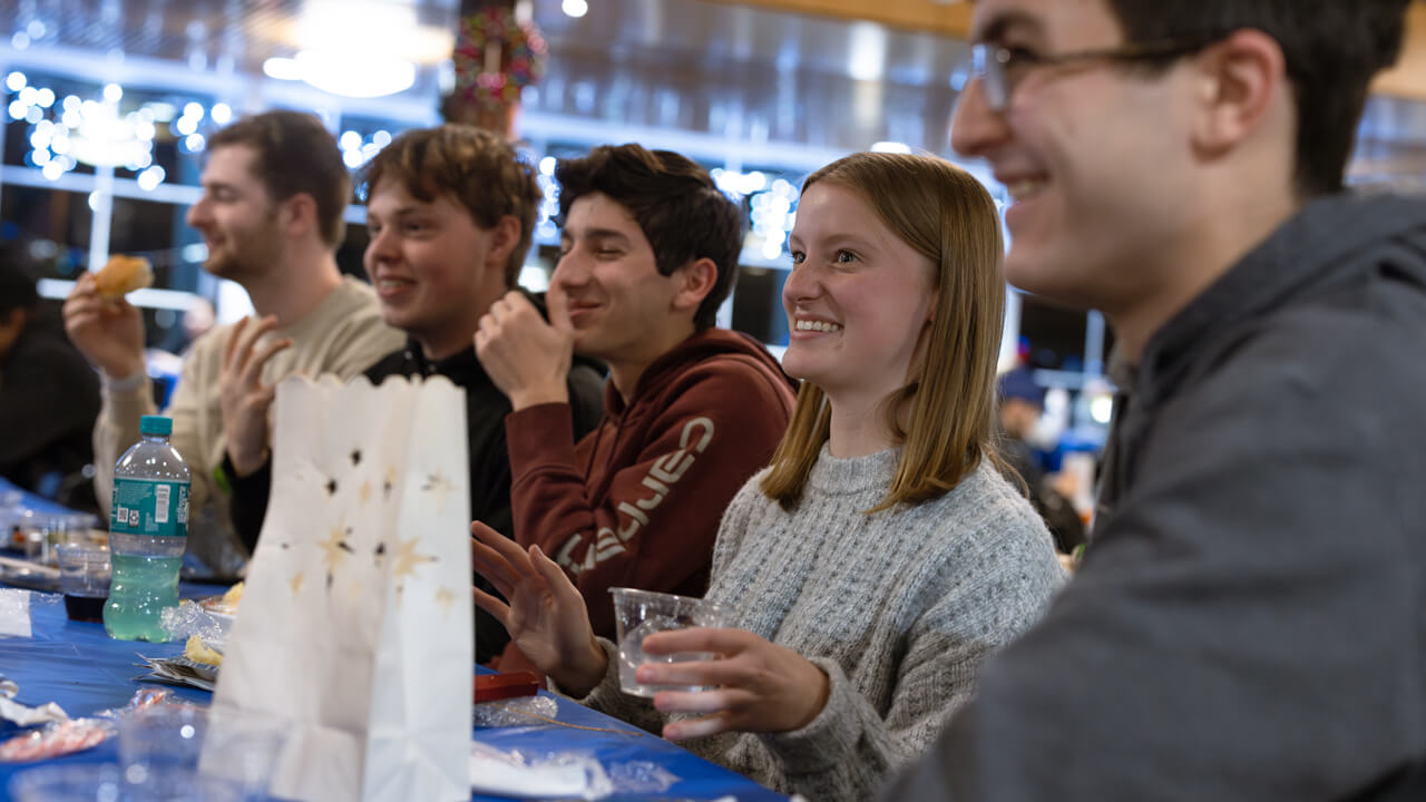 Individuals sitting at a table eating