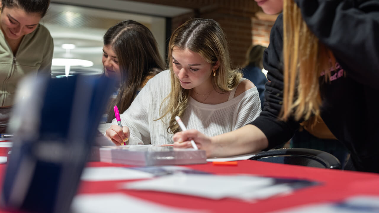 Individuals writing on cards