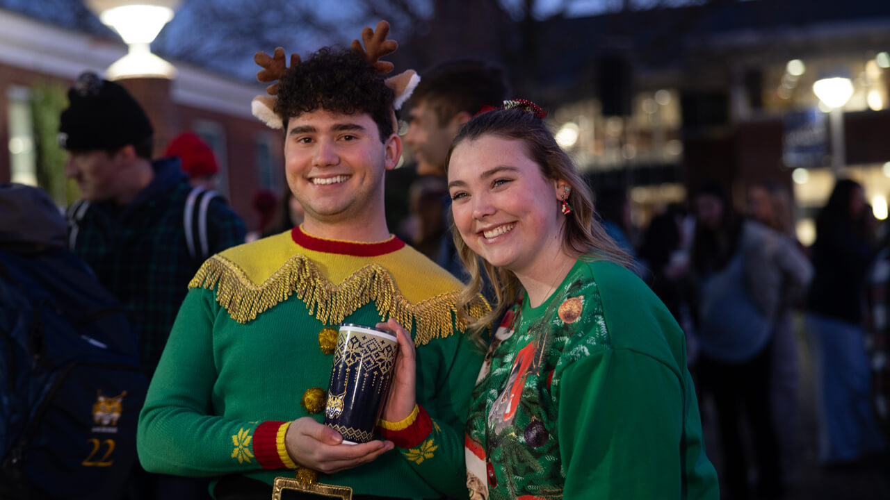 People pose for a photo holding a cup