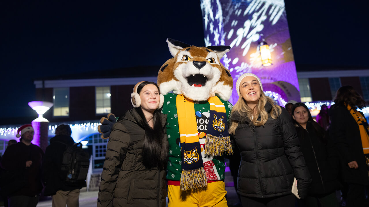 Boomer the mascot poses for a photo with students