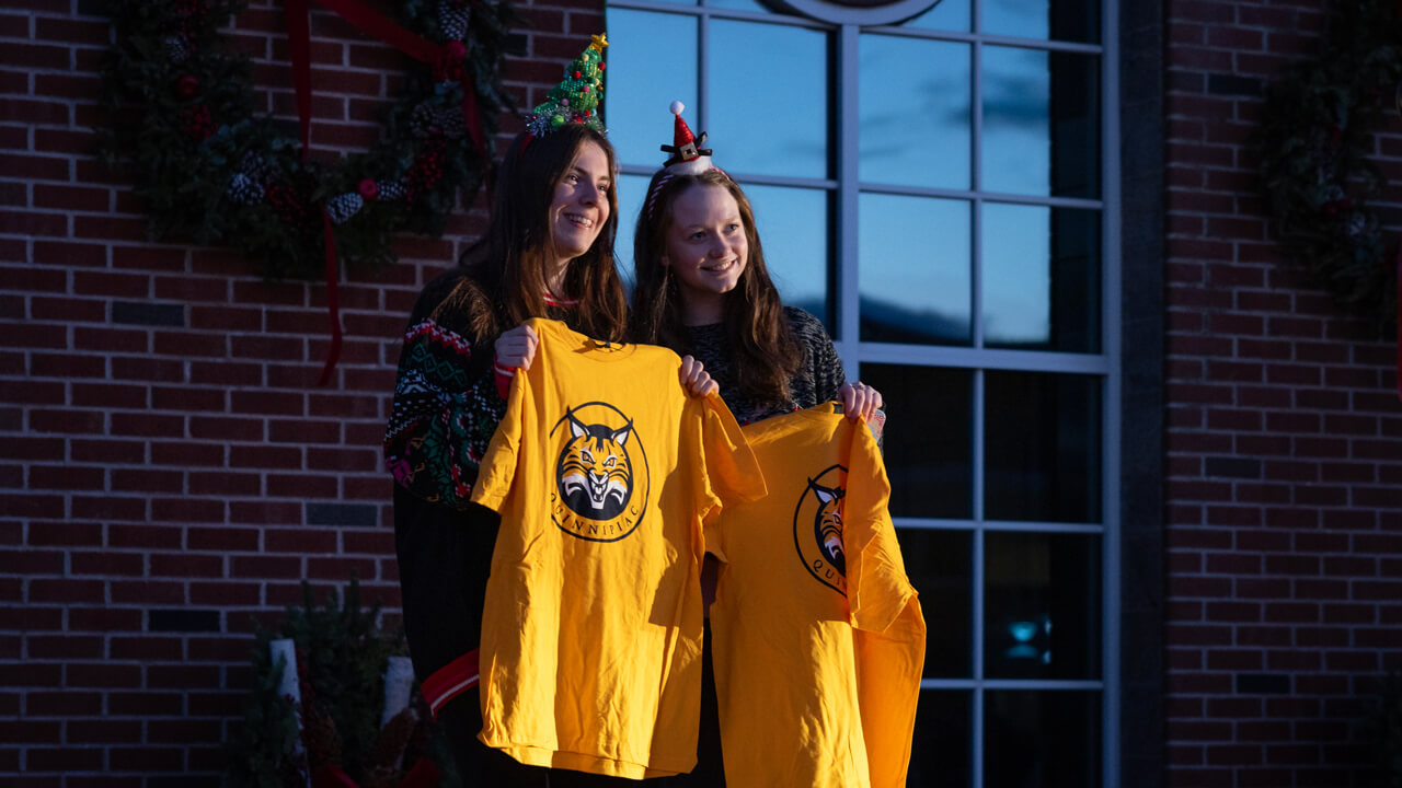 People pose while holding a shirt