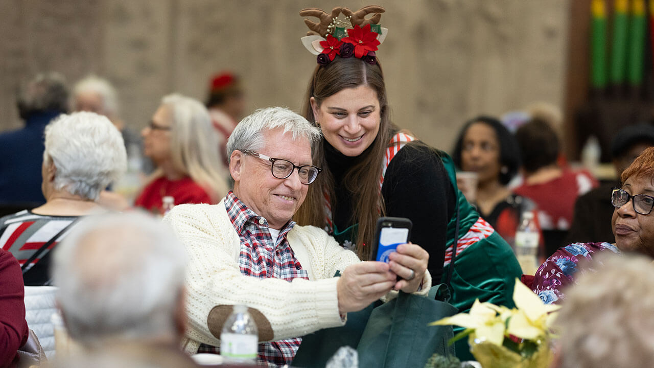 A senior citizen and Quinnipiac faculty member take a selfie.