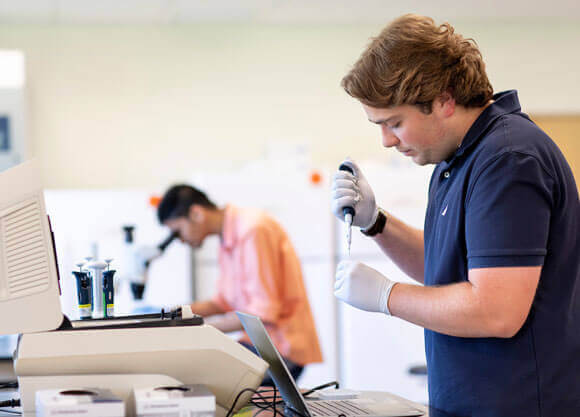 Students work with equipment in the biology laboratory.