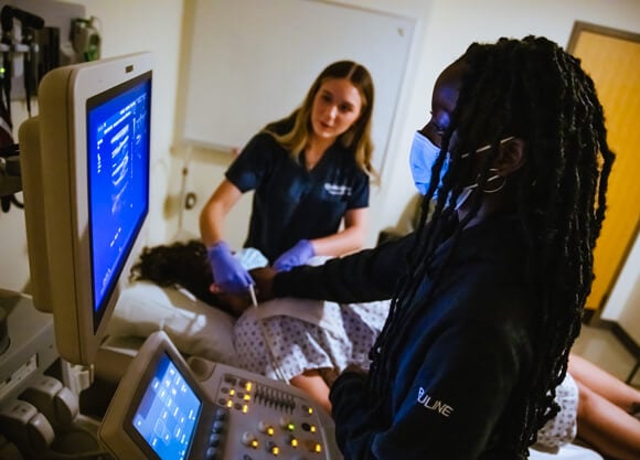 High school student being taught how to use a sonograph.