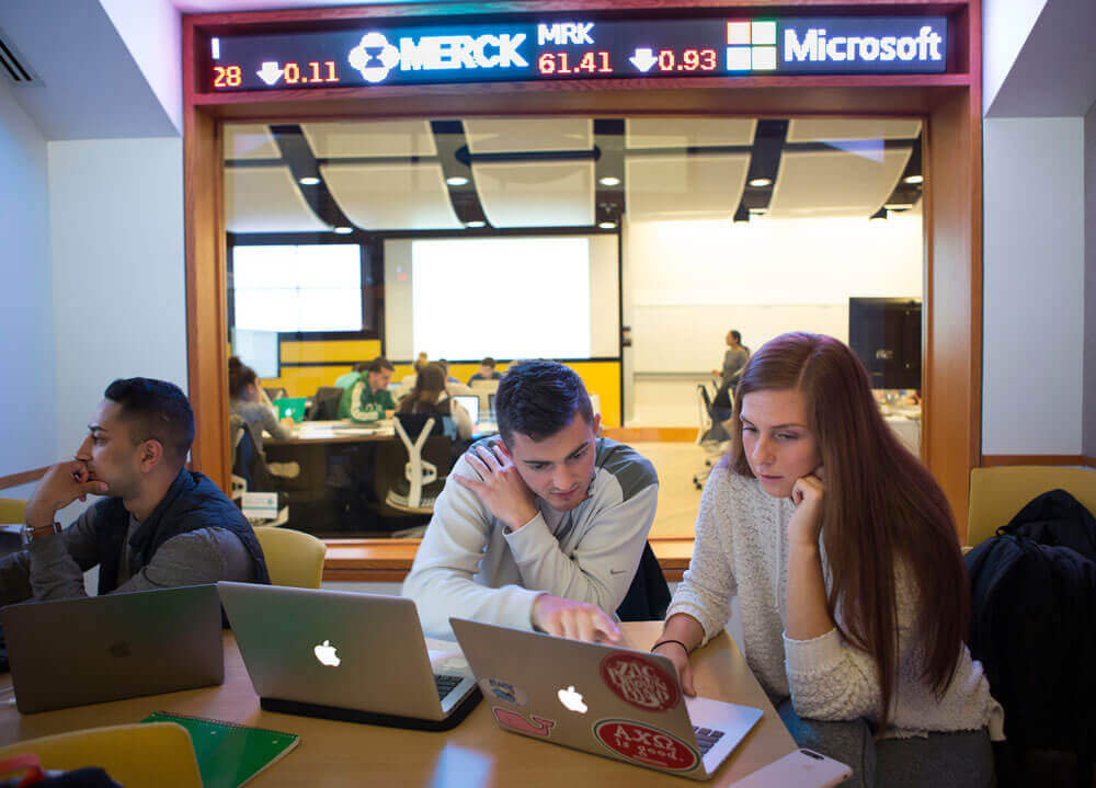 Students work on their laptops in the study room outside the Financial Technology Center in Quinnipiac's School of Business