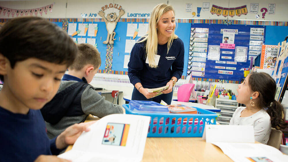 A business student listens attentively to an elementary schooler