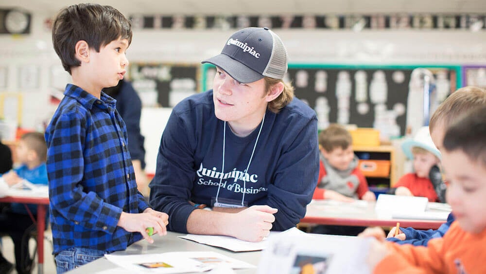 A business student talks to an elementary school student