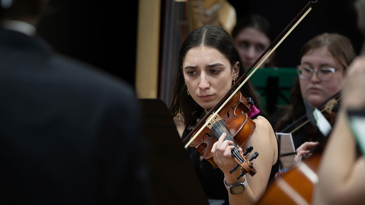 A student plays violin during their winter concert in Buckman Theater.